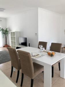 mesa de comedor con sillas y mesa blanca en Azores Terrace Apartment T2, en Ponta Delgada
