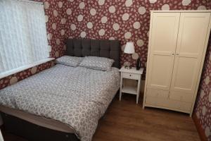a bedroom with a bed and a dresser and a cabinet at cosy 3-bed bungalow nec airport close to amenities in Birmingham
