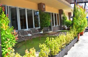 a patio with chairs and tables in front of a building at JJ Villa in Khon Kaen
