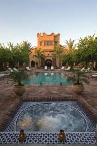 een groot zwembad met een huis op de achtergrond bij Riad Jnane Ines in Taroudant