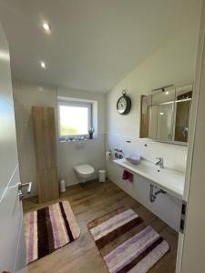 uma casa de banho com um lavatório, um WC e um espelho. em Ferienwohnung in Lonsee-Ettlenschieß em Lonsee