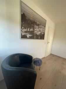 uma sala de estar com um sofá azul e uma fotografia em Ferienwohnung in Lonsee-Ettlenschieß em Lonsee