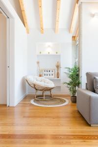 ein Wohnzimmer mit einer Couch und einem Ottomanen in der Unterkunft ORM Prado Apartment in Porto