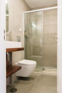ein Badezimmer mit Toilette und Glasdusche in der Unterkunft ORM Prado Apartment in Porto