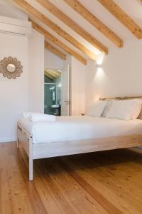 ポルトにあるORM Prado Apartmentのウッドフロアの客室で、白いベッド1台が備わります。