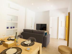 ein Wohnzimmer mit einem Sofa und einem Tisch mit Weingläsern in der Unterkunft Calle Pintado 21 Bajo in Estepona
