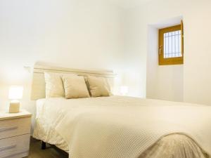 ein weißes Schlafzimmer mit einem großen Bett und einem Fenster in der Unterkunft Calle Pintado 21 Bajo in Estepona