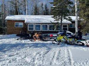 a group of motorcycles parked in the snow in front of a house at Air-Dale Lodge in Hawk Junction