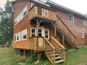 Cette grande maison en bois est accessible par des escaliers. dans l'établissement Air-Dale Lodge, à Hawk Junction