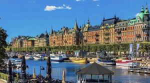 a large building with a bunch of boats in the water at Stadsporten Nacka in Nacka