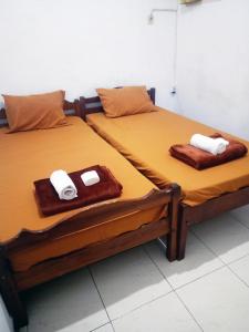 two twin beds sitting next to each other with towels on them at Moshi Moshi in Probolinggo