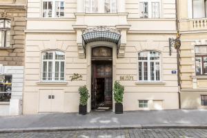 a building with a door and two potted plants at Hotel Josefine in Vienna