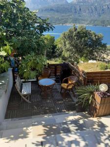 a patio with tables and chairs and a view of the water at Casa de Laza Apartments in Herceg-Novi