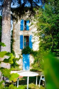 a table in front of a building with blue doors at La tour de guet Maison atypique in Castellane
