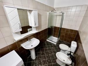 a bathroom with two toilets and a sink and a shower at Mermaid - apartment in Durrës