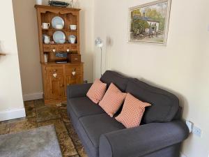 Jollys of Goodrich في Goodrich: غرفة معيشة مع أريكة عليها وسادتين