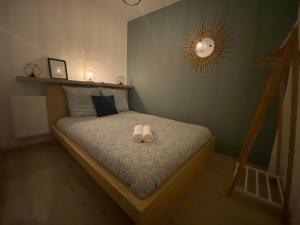 een slaapkamer met een bed met twee schoenen erop bij NEW Le Cocon Des Humanistes in Sélestat