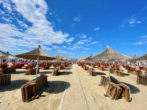 a beach with chairs and umbrellas on the sand at Mermaid - apartment in Durrës
