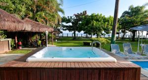 a hot tub sitting on top of a wooden deck at Indaiá Praia Hotel in Bertioga