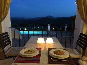 a table with two plates of food on a balcony at Casa Vesta in Zufre