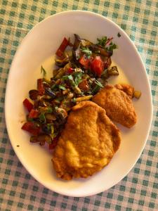 un plato de comida con pollo y verduras en una mesa en Claudia, en Eforie Sud
