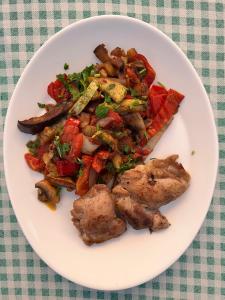 un plato de comida con carne y verduras en una mesa en Claudia, en Eforie Sud