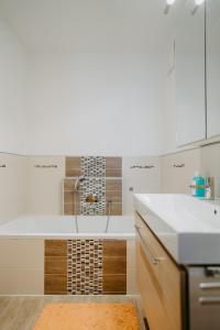 eine weiße Küche mit einem Waschbecken und einer Badewanne in der Unterkunft Apartment RADO 75m2 mit Garten und Terrasse in Winden am See