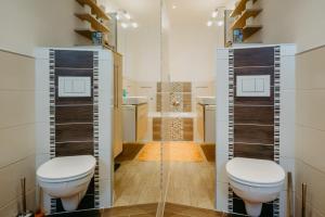 a bathroom with two toilets and a shower at Apartment RADO 75m2 mit Garten und Terrasse in Winden am See