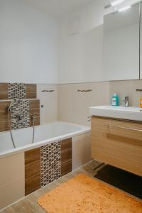 a bathroom with a tub and a sink at Apartment RADO 75m2 mit Garten und Terrasse in Winden am See