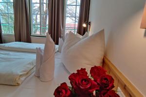 ein Hotelzimmer mit 2 Betten und roten Rosen auf dem Bett in der Unterkunft Theater- und Feriendorf Königsleitn GmbH in Litschau