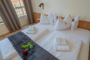 ein Hotelzimmer mit 2 Betten mit weißer Bettwäsche in der Unterkunft Theater- und Feriendorf Königsleitn GmbH in Litschau