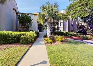 a walkway in front of a building with palm trees at South Beach Pearl in Hilton Head Island