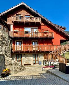 a large red building with a balcony on it at Hotel Piccolo Chalet in Claviere