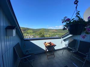 a balcony with chairs and a table with a view at Ferienwohnung An der Spitze in Winterberg