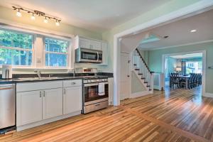 a kitchen with white cabinets and a hard wood floor at Downtown Retreat with Grill, Fire Pit and Wet Bar in Lake George