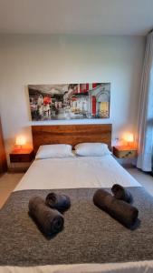 a bedroom with a large bed with a painting on the wall at Neot Golf Caesarea Garden Apartment in Caesarea