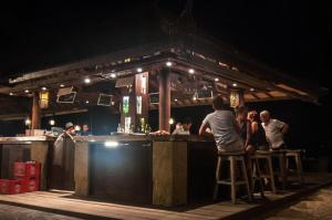 un grupo de personas de pie en un bar por la noche en Ambary House Gili Trawangan- 2 BR Private Villa, Pool, en Gili Trawangan