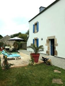 a white house with a patio and a pool at chambres d'hôtes les mésanges avec salle d'eau privative pdj compris in Kersaint-Plabennec