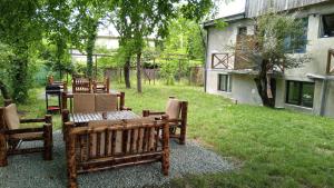 a group of wooden benches sitting in a yard at Villa PorTina in Ambrolauri