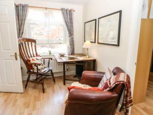 a living room with a couch and a table and a chair at 3 Westgate Mews in Ripon