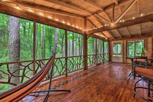 eine Veranda mit Hängematte im Wald in der Unterkunft Tranquil Greentown Cabin with Screened Porch! in Greentown