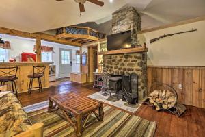 a living room with a stone fireplace in a house at Trails and Creek On-Site Tranquil Greentown Cabin in Greentown