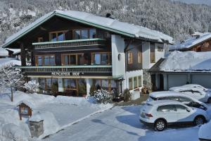 a house with a car parked in the snow at Gästehaus Münchner Hof in Reit im Winkl
