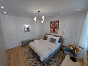 a bedroom with a bed and a chandelier at Saint Raphael's apartment, classé 3 étoiles in Saint-Raphaël