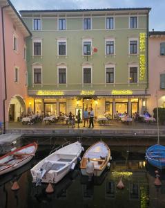 a hotel with boats in the water in front of a building at Hotel Benaco in Nago-Torbole