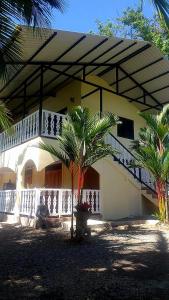 ein Haus mit einer Palme davor in der Unterkunft Suites Chile Verde in Manzanillo