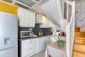 a kitchen with white cabinets and a microwave at Le Gite de Tournoel in Volvic