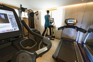 a woman in a room with a gym at Beausite Park Hotel & Spa in Wengen