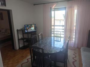 a dining room with a glass table and a television at Apartmani Cera in Soko Banja