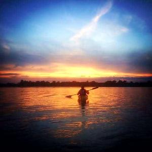 una persona en un kayak en el agua al atardecer en Sunrise, en Tappernøje